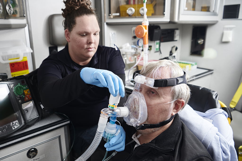 The photo shows a patient getting a nebulizer via CPAP.