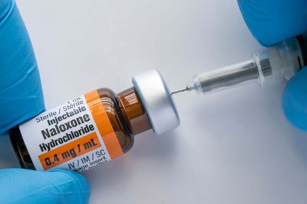 A person using a Naloxone vial with a syringe stock photo
