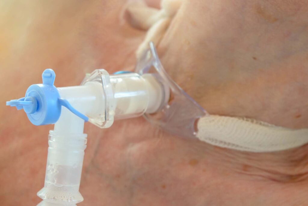 Patient with tracheostomy use ventilator for breathing.